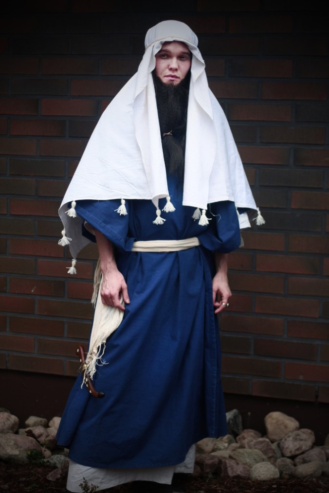 Uuden testamentinaikaiseen juutalaispukuun pukeutunut parraskas mies.