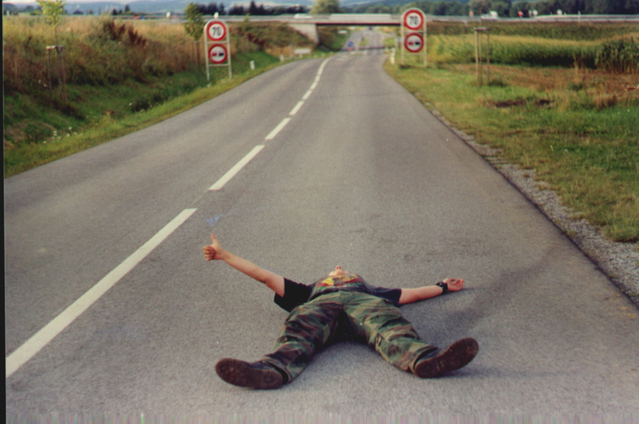 liftaaja makaa autotiellä peukku ojossa