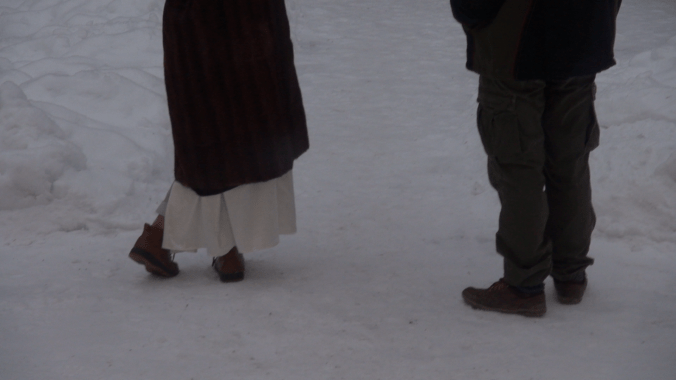 Kaksi ihmistä seisomassa lumihangessa, vyötäröstä alaspäin.