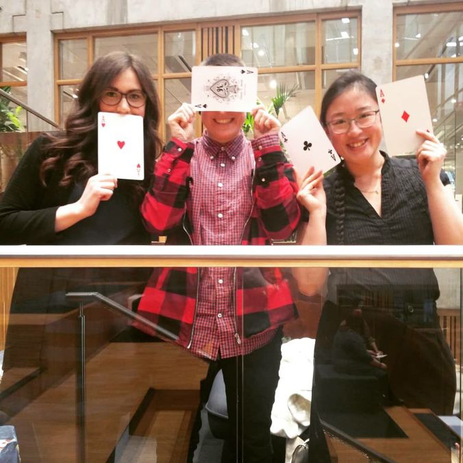 Kuvassa pääjärjestäjät pitelivät pelikortteja.