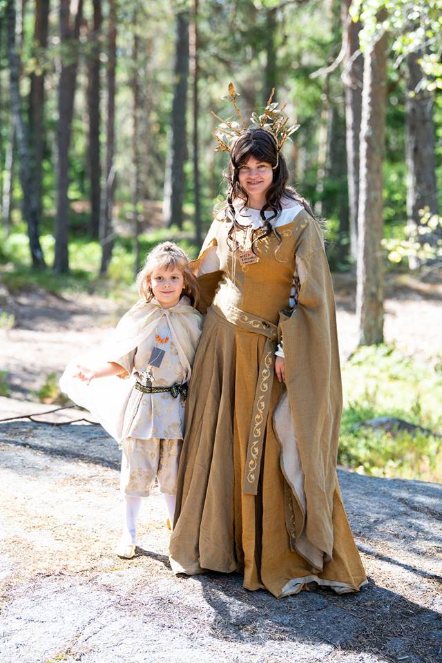 Pienihaltiaprinssi haltiakuningattaren kanssa, vaatteissa kultaa ja helmiäistä.