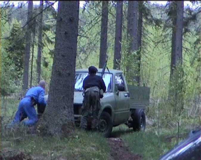 Kuvassa työnnetään kuormuria kivääriä pidellen.