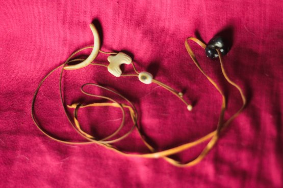 Kuvassa on kaksi korua: toinen on kivi ja toinen on luinen koru, jossa on mm. kuunsirppi.