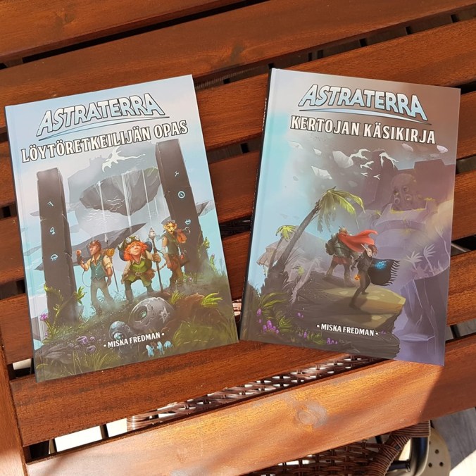 Kuvassa roolipelikirjat Astraterra löytöretkeilijän opas ja kertojan käsikirja
