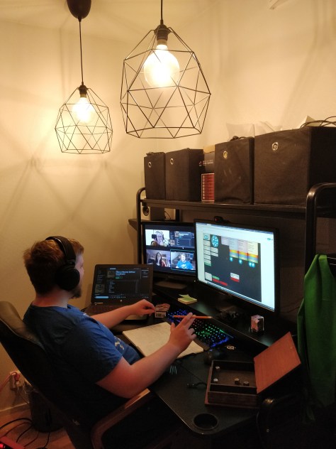 Elmeri istumassa etäpelin äärellä. Yhdessä näytössä chatti, toisessa videopuhelu ja kolmannessa virutaalinen roolipelipöytä.