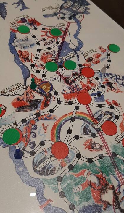 Kuvassa pelilauta ja afrikan tähti lautapelin tyylisiä nakkuloita.