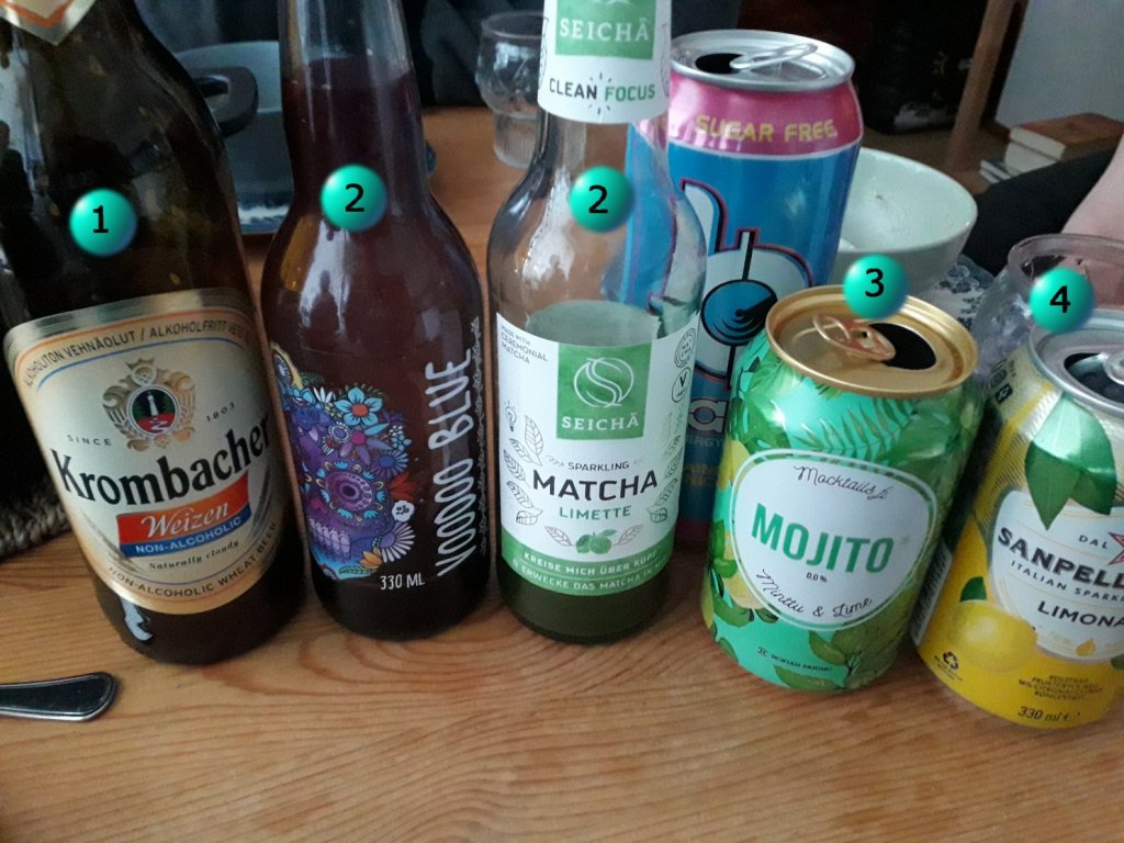 Viisi erlaista pulloa tai tölkkiä. Mukana alkoholitonta olutta, voodoo blue -limonadia, matchaa, mojitoa ja sitruunalimonadia. Taustalla tölkki energiajuomaa.