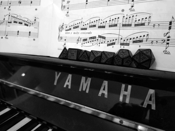 Yamaha-piano, jonka päällä on mustia noppia ja nuotteja.